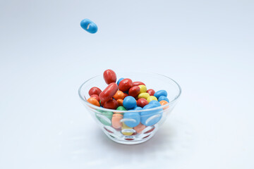 Colorful candy in a glass bowl on white background 