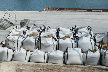 Pile of big bag of sand for wall construction and foundation screed on construction sites.
