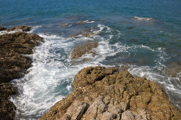 Ocean waves breaking at the rocky coast. Thailand