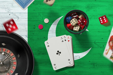Pakistan casino theme. Aces in poker game, cards and chips on red table with national flag background. Gambling and betting.