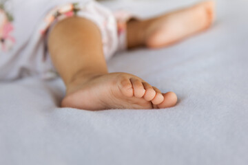 Adorable baby feet on pastel background in a selective focus