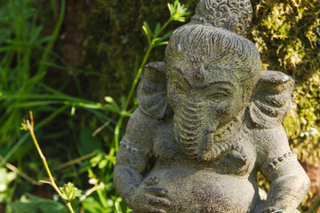 ganesh stone statue outdoors decoration among the vegetation