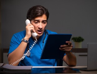 Young handsome doctor working night shift in hospital