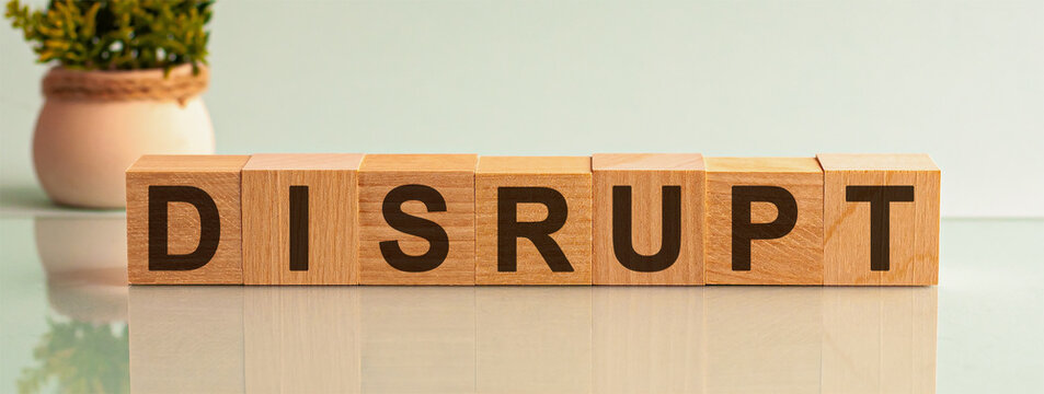 DISRUPT word written on wood block. Text on wooden table for your desing, concept.