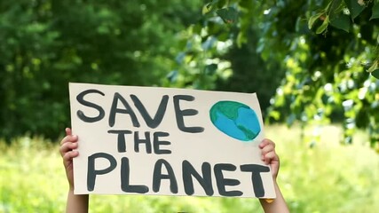Young kid child holding in hands green posters at global climate strike. youth protesting for safe ecology,global warming and pollution, plastic in public demonstration. Climate Strike. Eco Activism