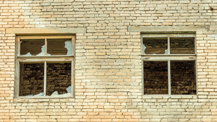 Fototapeta na wymiar broken Windows of an abandoned brick building