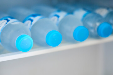 Bottles with cold water in refrigerator, closeup