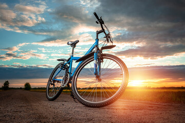 Fototapeta na wymiar Bike on a sunset background. The concept of a healthy lifestyle, sports training, cardio load. Copy space.