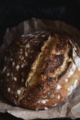 Baked bread of sourdough. Artisan bread on dark background. Bread of sourdough, homemade and natural creation. The sourdough has natural yeast, which makes the food healthier, as well as rich.