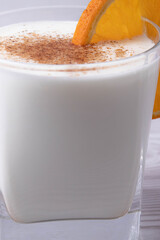 sweet milky desert or coconut milk and a slice of orange in a glass