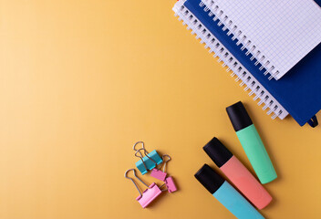 different colorful stationary items on yellow surface of a desk