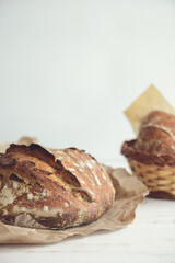 Baked bread of sourdough in hands. Artisan bread on light background. The bread of sourdough, homemade and natural creation. The sourdough has natural yeast, which makes the food healthier, as well as