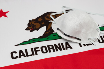 California state flag and N95 face mask. Concept of state and local government face covering...