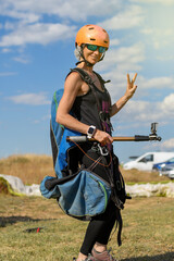 young girl smiling ready to do paragliding with a sports helmet and sunglasses on a sunny day