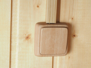 the switch in the color of wood is installed on a wooden wall in the house