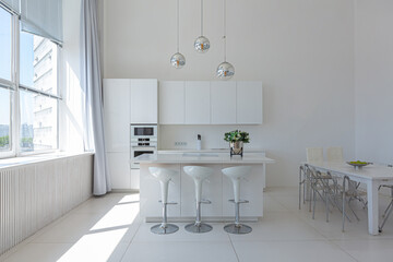 Cozy luxury modern interior design of a studio apartment in extra white colors with fashionable expensive furniture in a minimalist style. white tiled floor, kitchen, relaxation area and workplace