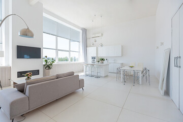 Cozy luxury modern interior design of a studio apartment in extra white colors with fashionable expensive furniture in a minimalist style. white tiled floor, kitchen, relaxation area and workplace