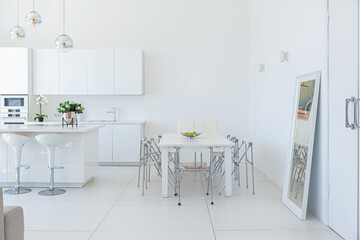 Cozy luxury modern interior design of a studio apartment in extra white colors with fashionable expensive furniture in a minimalist style. white tiled floor, kitchen, relaxation area and workplace