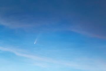 Comet C / 2020 F3 (NEOWISE) in bright sky. Bright comet on a cloudy evening sky.