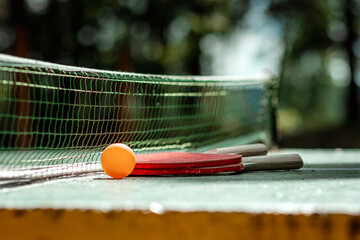 The concept of sports games, healthy lifestyle. Rackets for for ping pong and orange balls. Copy space, soft focus.