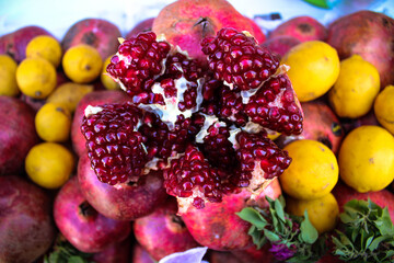 Open pomegranate from above with other fruits in the background