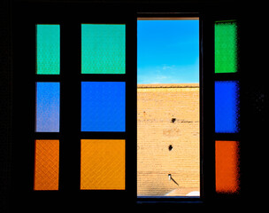 Wall seen through an open coloured glass window