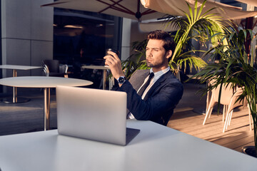 Working hard to achieve success. Thoughtful young modern man using computer while sitting at cafe