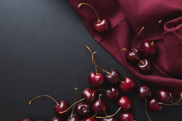 Cherry background. Cherries on a black top view. Elegant rich cherry background. Burgundy...