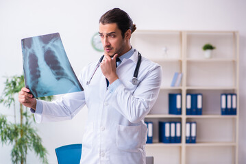 Young male handsome doctor working in the clinic