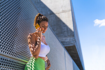 Beautiful Woman Having Phone Call Outdoors After Exercise. Lifestyle Concept.