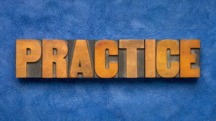practice - word abstract in vintage letterpress wood type blocks against blue textured paper,...