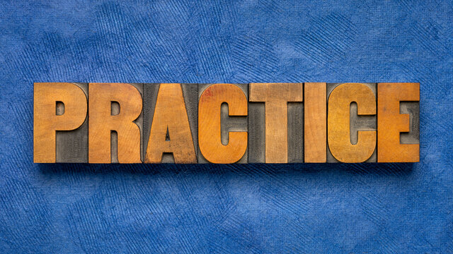 practice - word abstract in vintage letterpress wood type blocks against blue textured paper, education, training, business and personal development concept