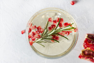 Sparkling wine, pomegranate seeds, rosemary sprig. Xmas beverage. Close up. View from above.