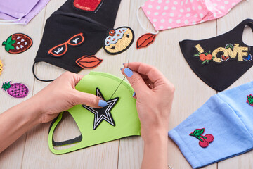 Woman sewing embroidered patches to face masks