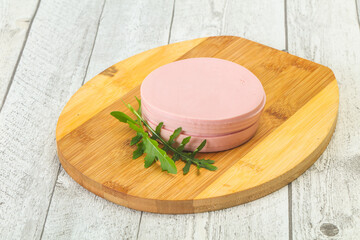 Sliced sausage over the wooden board