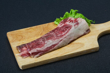 Raw beef bacon over wooden board