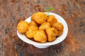 Sweet tasty profiteroles heap in the bowl