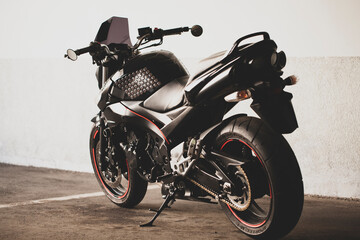 Plakat Sports black motorcycle on a background of an underground gray wall in the studio.