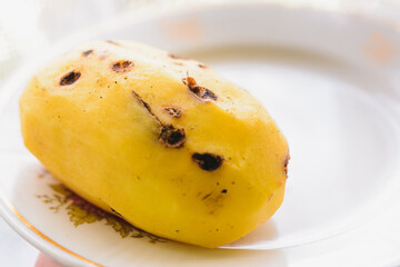 Big peeled new potatoes, yellow potatoes on a wooden board.