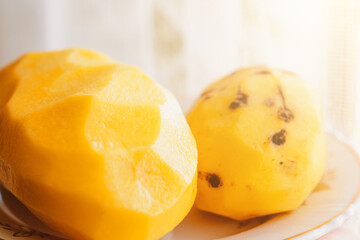 Big peeled new potatoes, yellow potatoes on a wooden board.