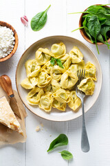 Ravioli with spinach and ricotta cheese on a white wooden table. Traditional Italian pasta. Top view.