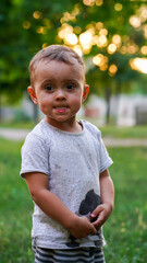 Portrait of cute little boy in summer park