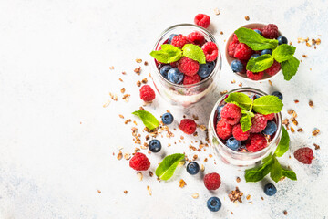 Parfait with granola, jam and fresh berries in the glass jar.