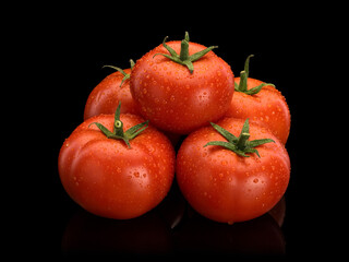 Pyramid combined from five ripe tomatoes covered with drops of water