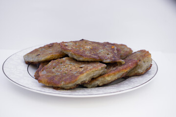 Belarusian cuisine. Pancakes from grated potatoes on a white plate and a light background