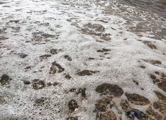 Texture of foamy bubbling large sea waves close-up.
