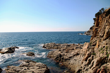 rocky coast of the mediterranean sea. Beautiful view of rocks with blue sea with waves, horizon under sunshine sky. Mediterranean Sea.
