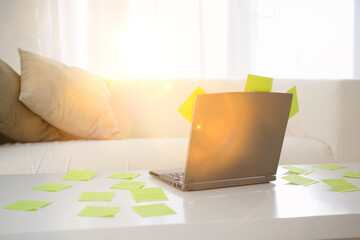 Adhesive notes scattered on table with laptop