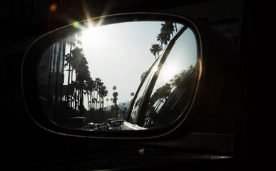 Fototapeta na wymiar Palm trees reflecting in car mirror