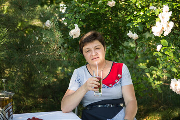 Picture of a middle-aged woman. Concept of emotions. Woman is happy to have rest outdoors after...